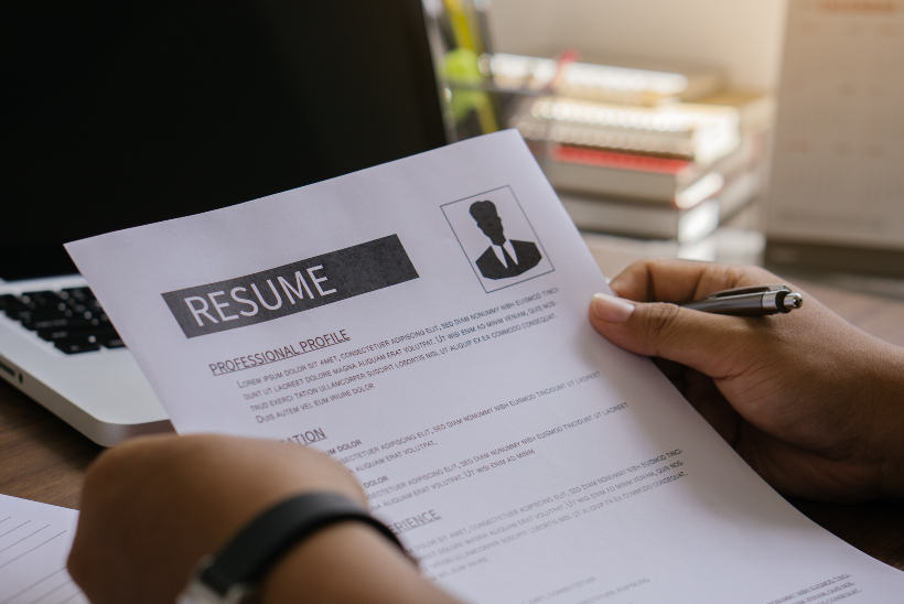 A resume in hands with a pen